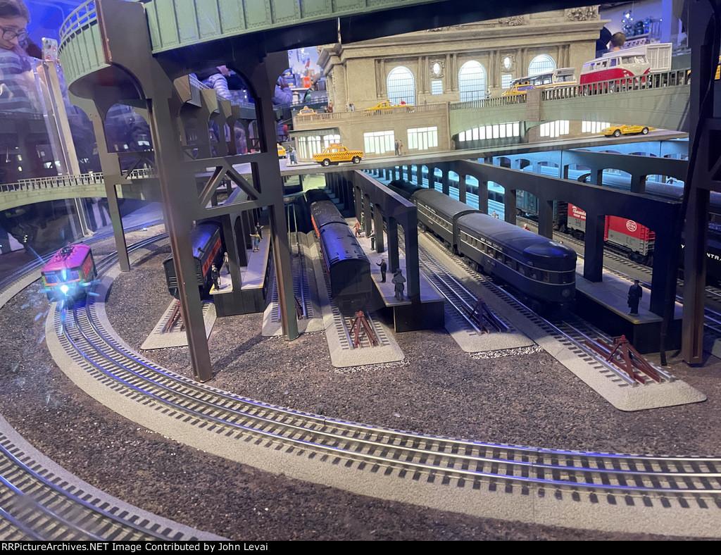 A model trolley car passing underneath model GCT